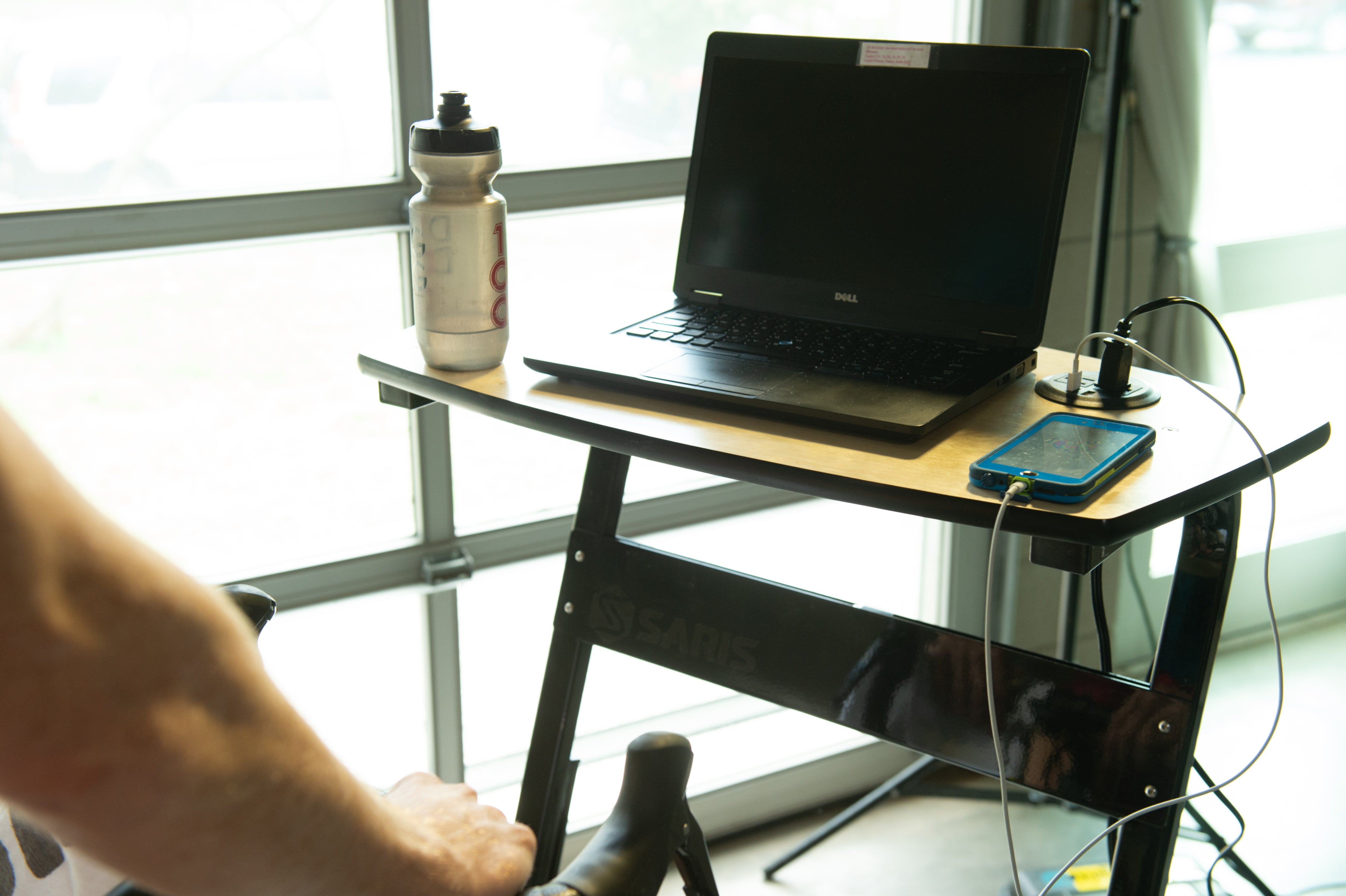 Cyclist working on laptop at the Saris TD1 Trainer Desk during indoor ride