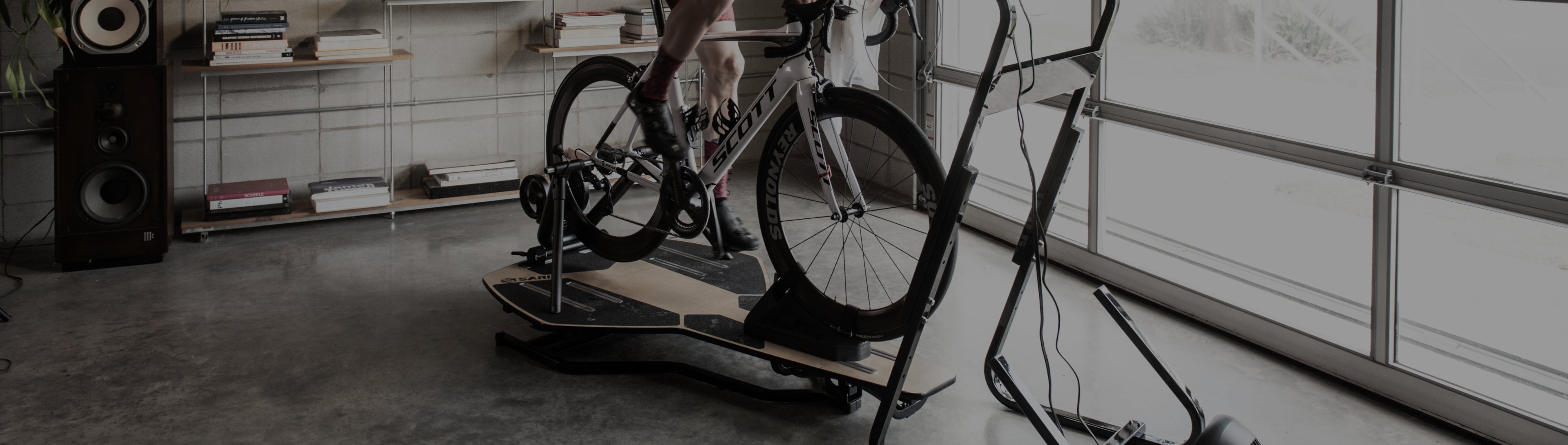 Cyclist riding Scott road bike on Saris MP1 Nfinity motion platform in a home gym