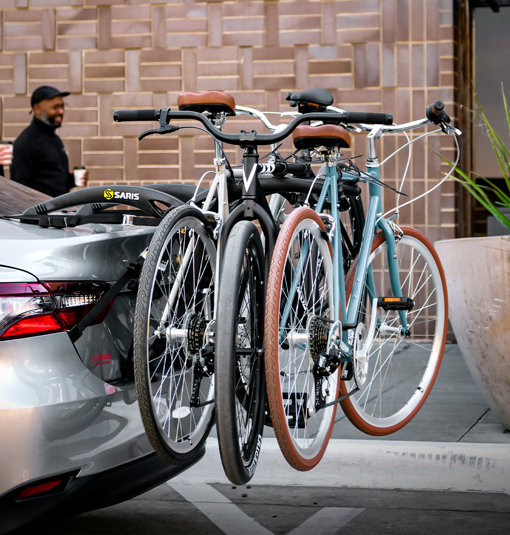 Family loading three bikes onto the Saris Bones 3-Bike Trunk Rack before a weekend ride