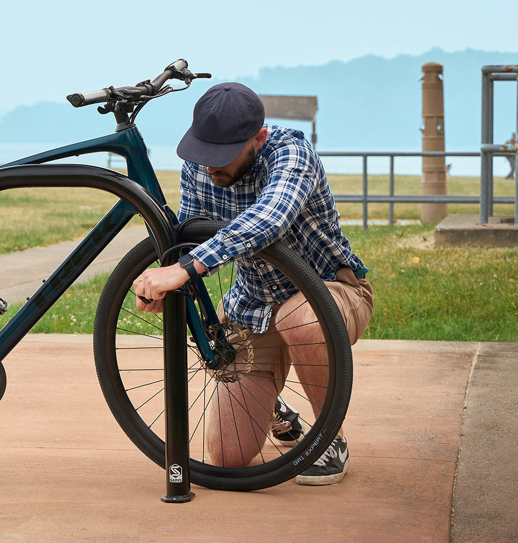 Saris Bike Dock — wall-mounted hook holding road bike by top tube in garage