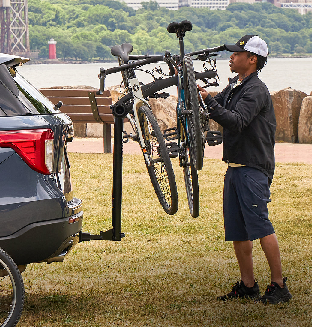 Family loading four bikes onto the Saris Bones 4-Bike Hitch Rack before a ride