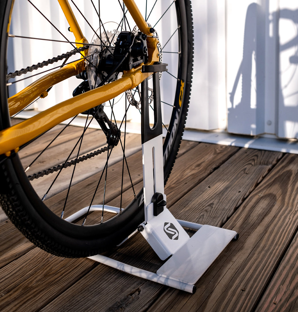 Saris Boss Rear Wheel Bike Stand holding a mountain bike — helmet hanging from handlebar