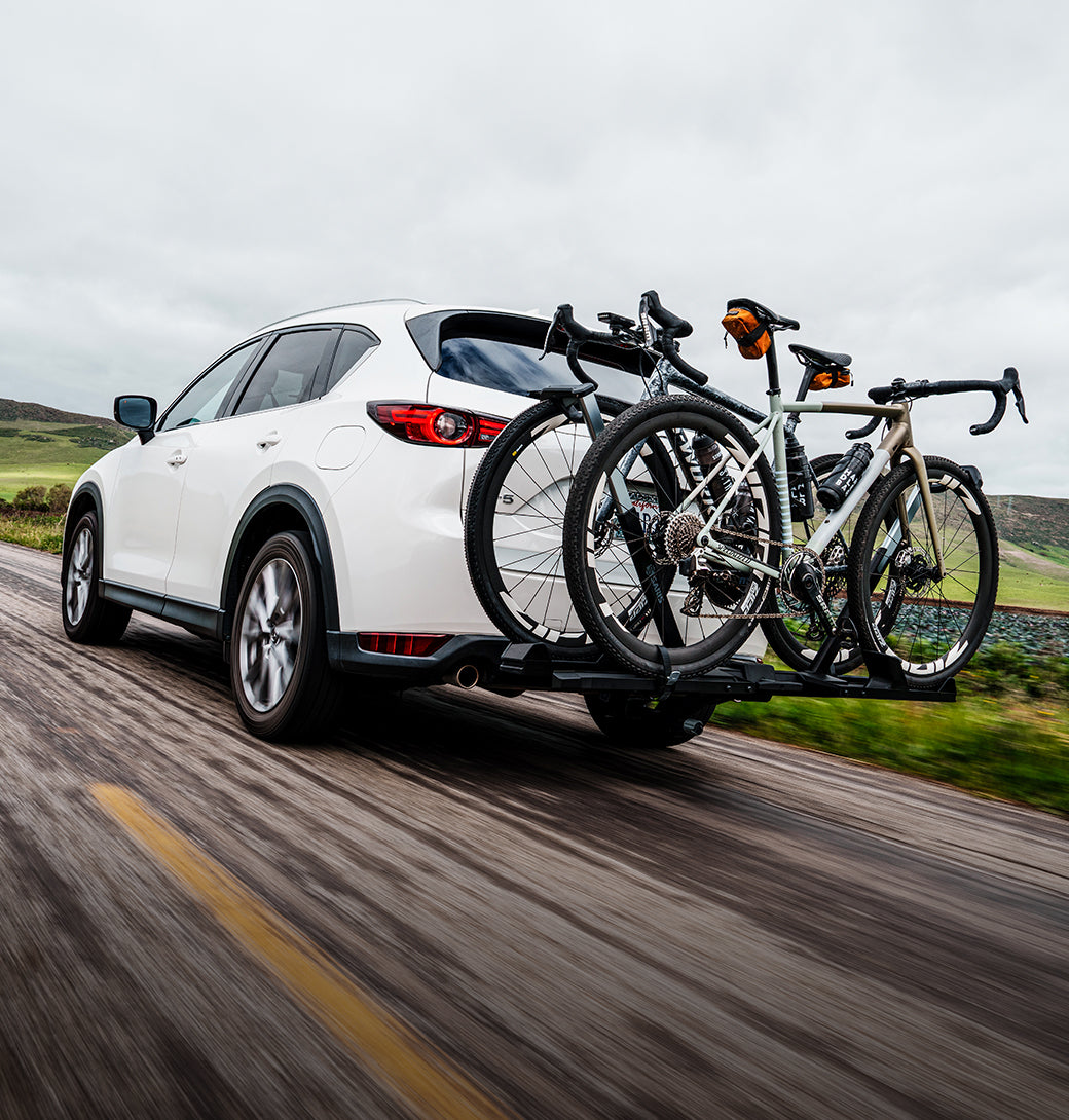 Saris SuperClamp G4 infographic — two road bikes on Mazda CX-5 driving through hills