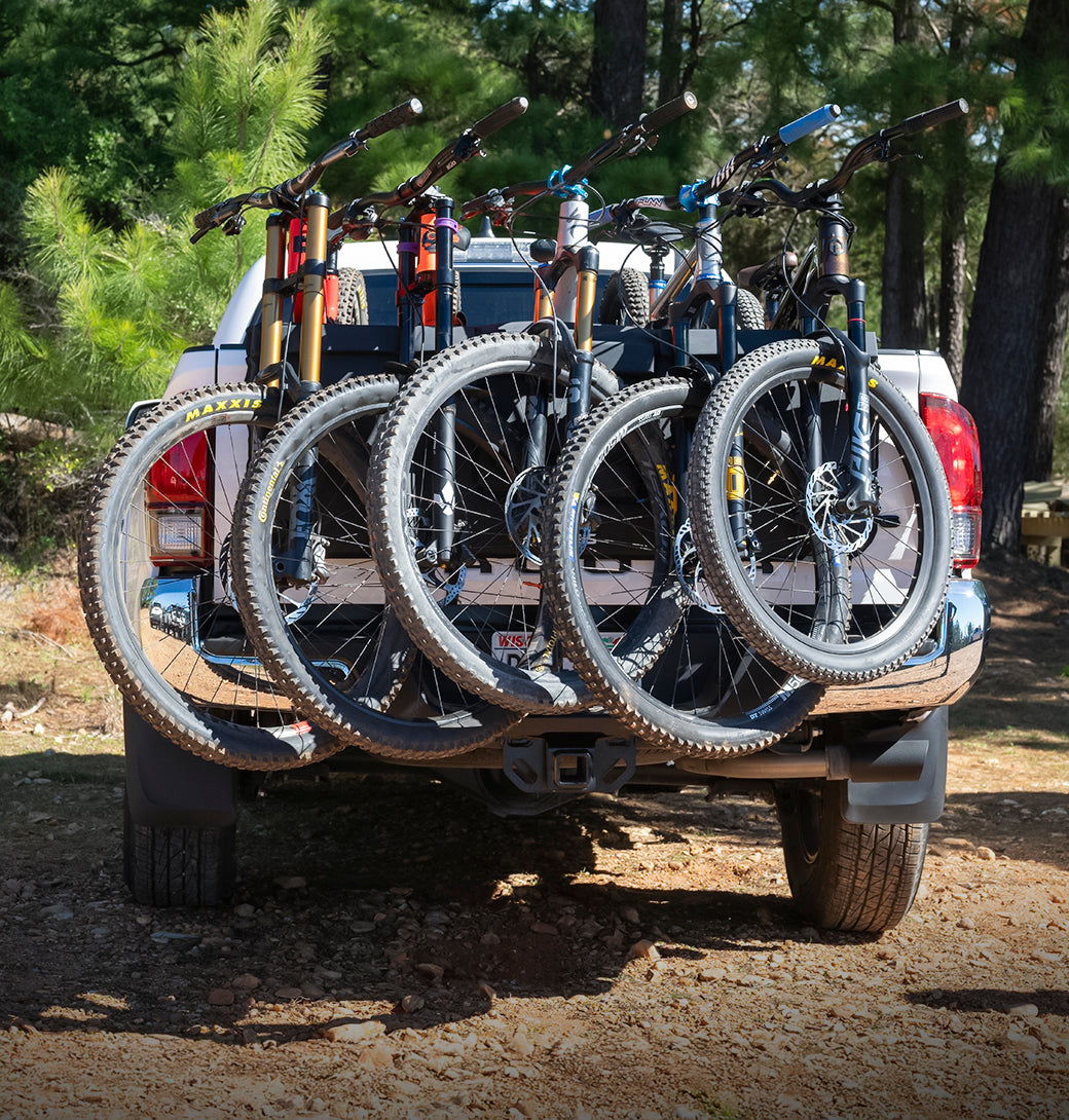 Three mountain bikes secured on the Saris Tailgate Pad — truck tailgate loaded